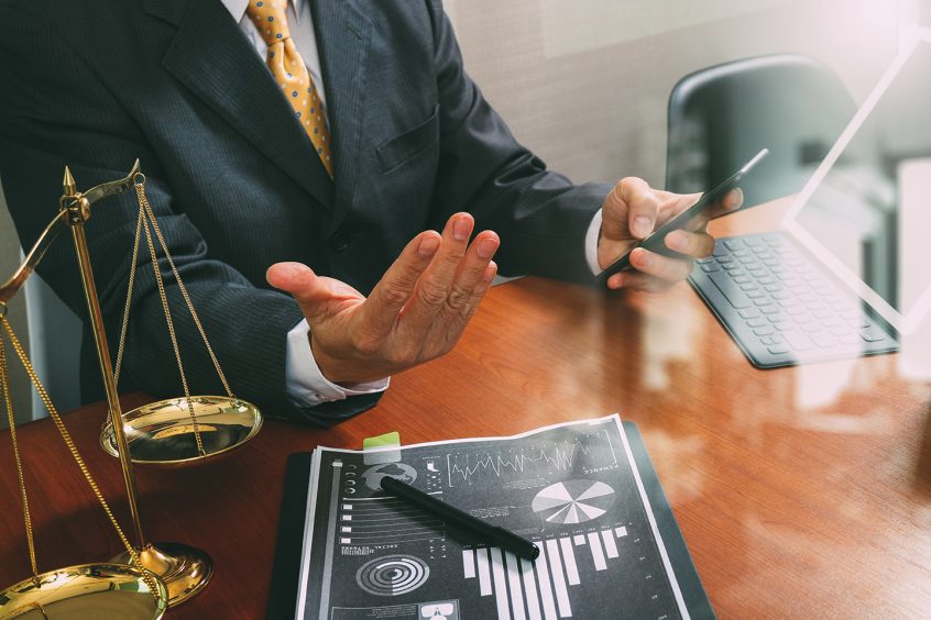 Male disability attorney sitting at a desk with a graph