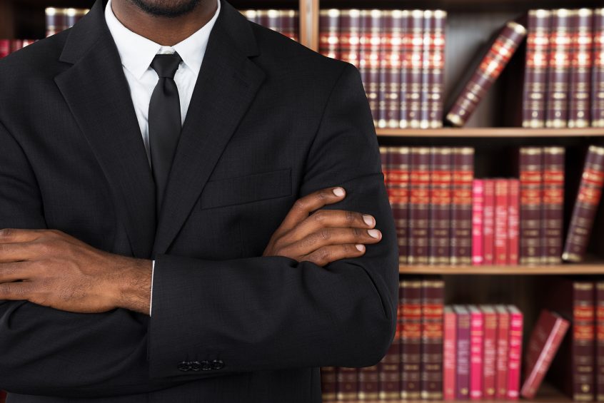 Male disability attorney standing in front of a bookcase